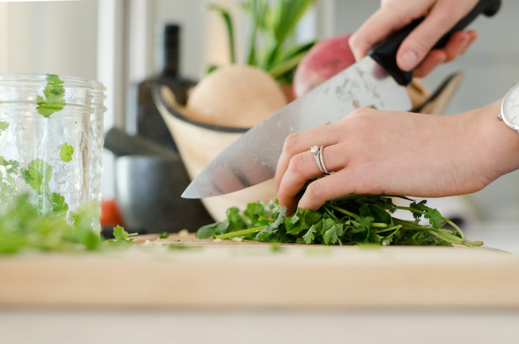 Person Cutting Vegetables with a Sharp Knife in the Kitchen