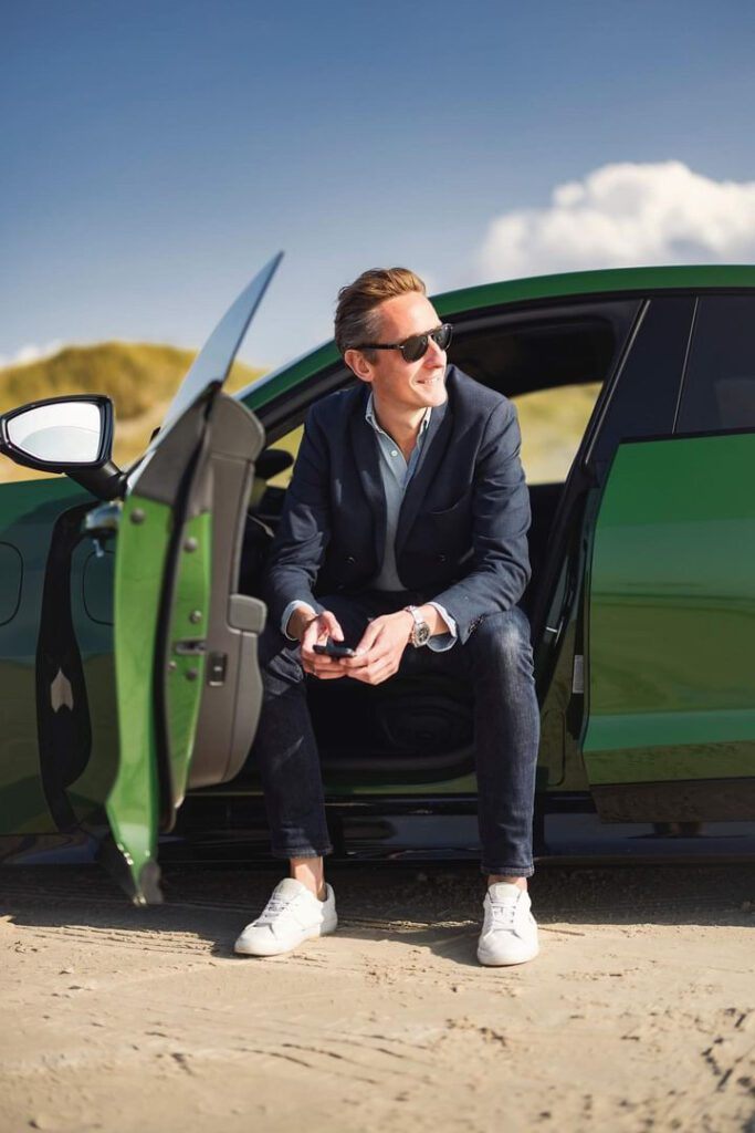Casper Lundmose Sitting in a Green Porsche Taycan